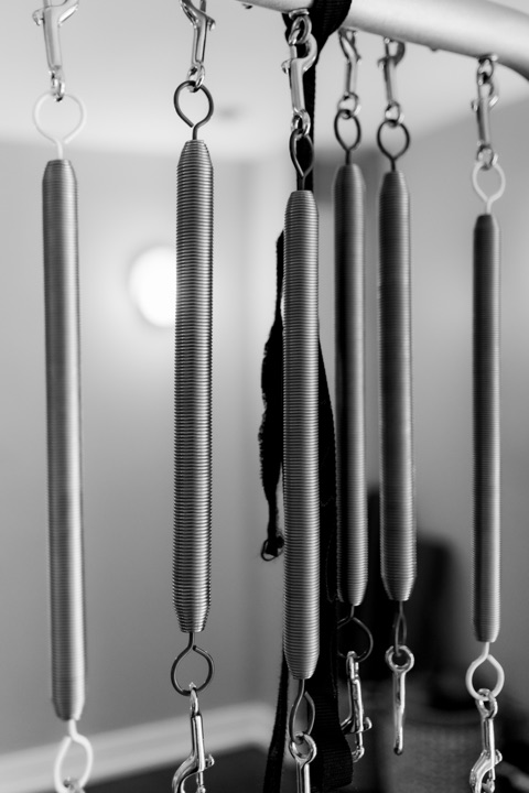 Black and white photograph of hanging Pilates springs